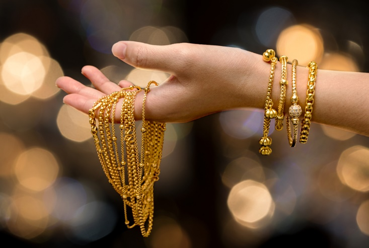 woman hand holding gold bracelet and jewelry